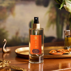 Room spray bottle with gold pump, clear glass and orange label