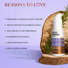 Just Herbs hair serum bottle on wood slice with rosemary sprigs