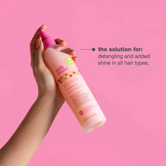 Milk Shake leave-in conditioner spray bottle held in hand, pink pump bottle