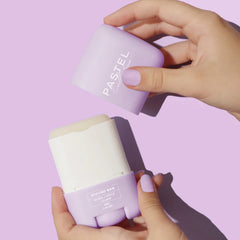 Hair styling bars in hands: lavender and white sticks; labels visible