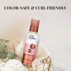 Hair oil bottle with copper cap, pink floral label and clear glass body