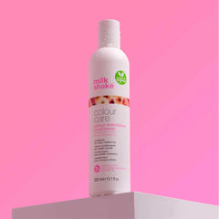 Milk Shake colour care conditioner bottle, 300 ml, held in hand; white with pink label