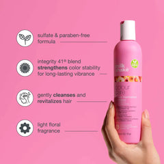 Pink colour care shampoo bottle held in hand, pump cap