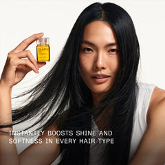 Olaplex No.7 Bonding Oil mini bottle in hand, amber-gold liquid and clear cap