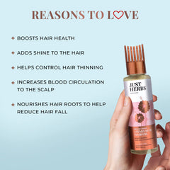 Hair oil bottle held in hand, copper cap and pink floral label