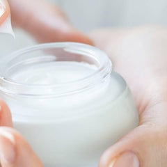 Open jar of white anti-wrinkle cream with smooth cream texture