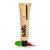 Toothpaste tube with black cap, beige-gold body, salt branding.
