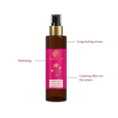 Body mist bottle with gold pump and front pink label on brown glass