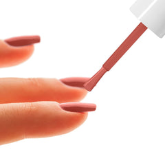 Hand applying coral-pink nail enamel with flat brush