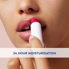Lip balm being applied to lips with a white stick; pink cherry tint
