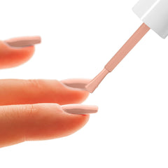 Nail enamel brush applying light pink polish to fingernails