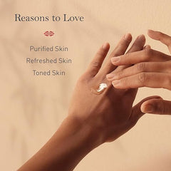 Hands applying rose jasmine face cleanser, with white product on fingertips