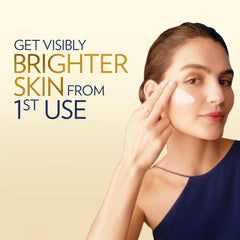 Skincare cream dabbed on woman's cheek and near eye, for brightening glow