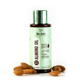 Almond oil bottle with green cap, surrounded by almonds