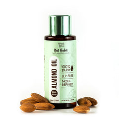 Almond oil bottle with green cap, surrounded by almonds