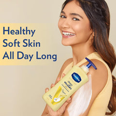 Vaseline deep moisture body lotion bottle held by a person, blue cap