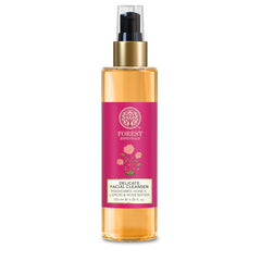 Amber facial cleanser bottle with gold pump and pink band label