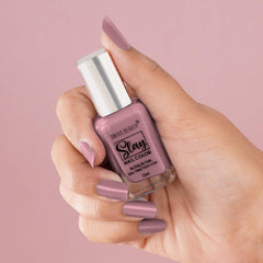 Lavender nail polish bottle held with lavender-coated fingernail
