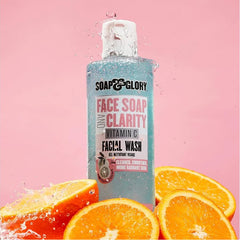 Turquoise vitamin C facial wash bottle with white cap, splashing water and orange slices