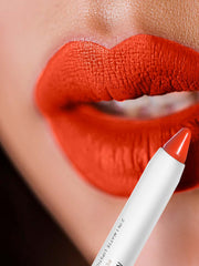 Orange-red matte lip crayon on lips, pointed white crayon tip with gold base