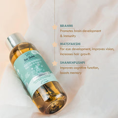 Hair and scalp oil bottle with amber liquid, teal label, metal cap, angled