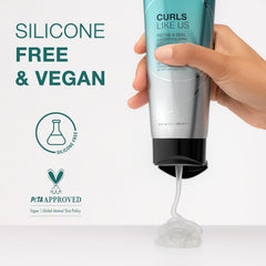Silicone-free vegan curl defining gel tube held in hand, teal and silver with black cap