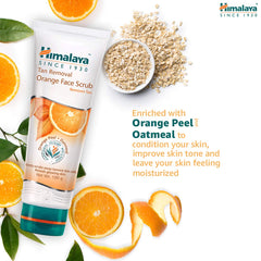 Orange face scrub tube beside bowl of oatmeal and orange peel slices