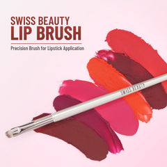 Lip brush lying over red and pink lipstick swatches
