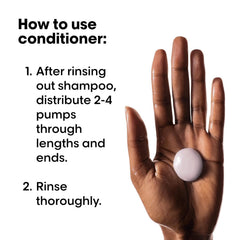 Vitamino Color Conditioner shown on a hand, dispensing product for hair conditioning