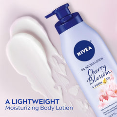 Cherry blossom body lotion bottle with cream dollop on arm, blue pump