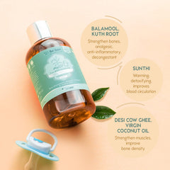 Baby massage oil bottle with silver cap, teal label, amber oil, and herbs