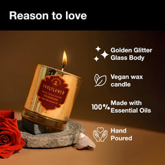 Glass votive candle with amber glitter glass body and flame, tilted on a stone base