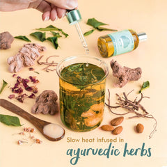 Baby massage oil bottle with dropper pouring oil into a glass bowl of herbs