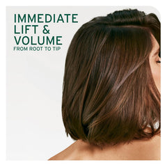 Hair styled with lift and volume, showing fuller-looking hair at the crown