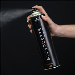 Hand holding Schwarzkopf Silhouette Super Hold hair lacquer spray can, 400g