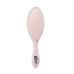 Pink oval detangling hairbrush showing cushion pad texture and curved handle