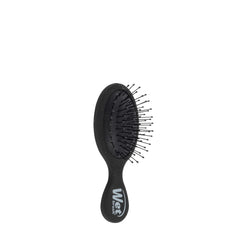 Black mini detangling brush with outward bristle tips on oval cushion