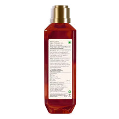 Body oil bottle with gold pump, amber glass, ingredient label on back