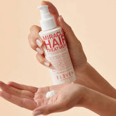 Eleven Australia Miracle Hair Treatment pump bottle with white lotion on hand