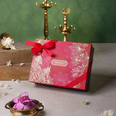 Body care gift set box in pink-red with white leaf pattern and red ribbon