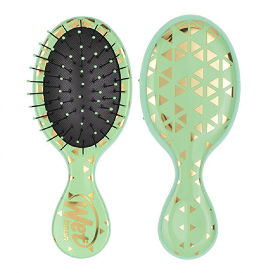 Mini detangling brush with jade-green handle, black pin head, geometric confetti backing