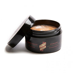 Open hair pomade jar showing creme-colored product inside, black label