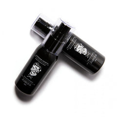 Two black serum bottles with pump caps, side view