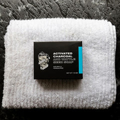 Charcoal soap box on white terry cloth, black label with blue stripe, 110 g