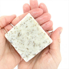 Speckled square soap bar held in hand