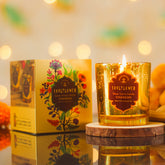 Glass votive candle in amber gold glitter jar with flame and decorative CHANDAN label