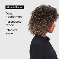 Hair repair oil with curly hair, side profile and dark jacket