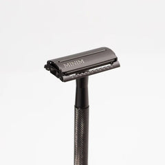 Gunmetal safety razor with MINIM logo on open comb head and textured grip