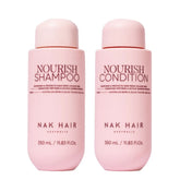 NAK Hair Nourish shampoo and conditioner bottles, pink 350 mL each, red caps