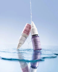 Hair color-fix bottle with dropper dispensing into water surface